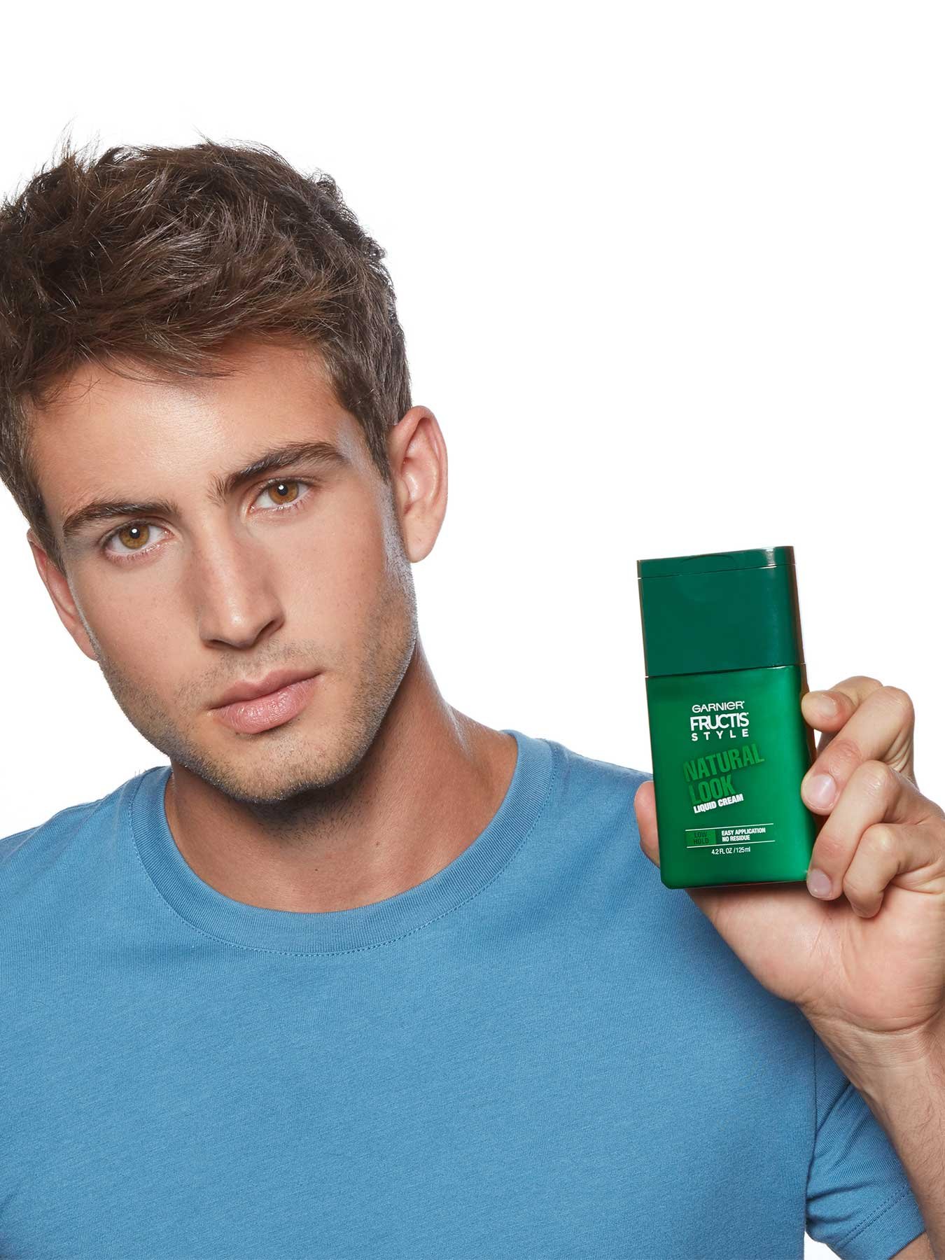 Model holding Natural Look Liquid Hair Cream for Men, No Drying Alcohol.